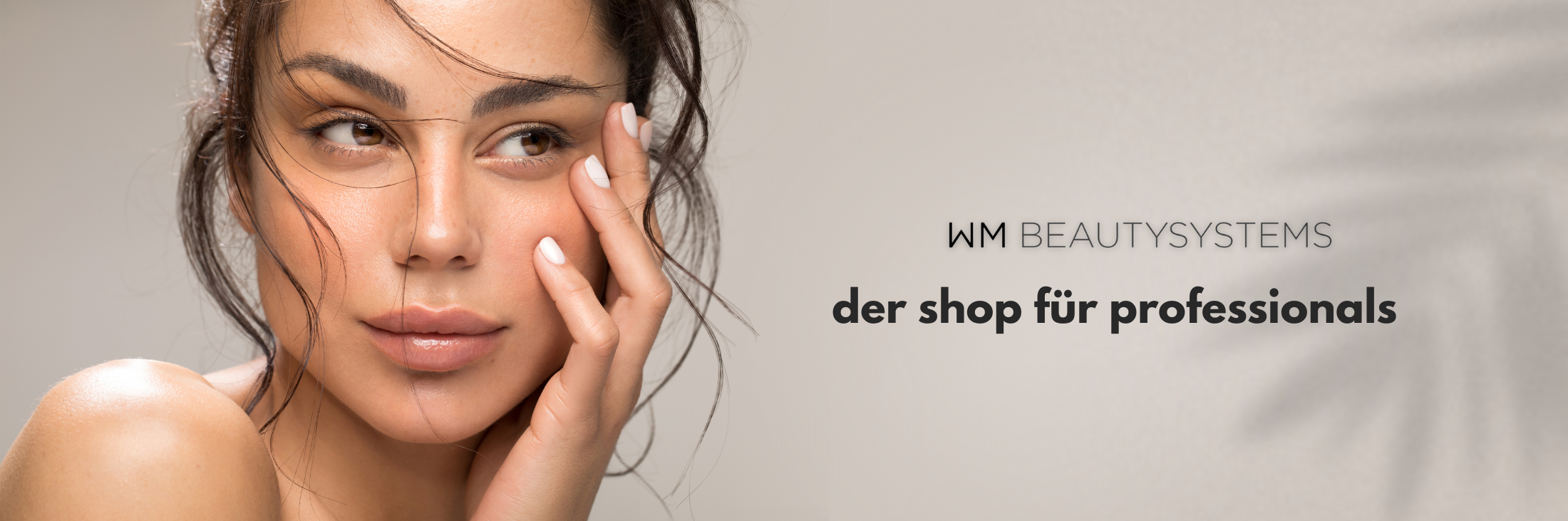 Gesichtaufnahme von dunkelhaarigem Model mit Textelement, auf dem steht: WM Beautysystems – Der Shop für Professionals